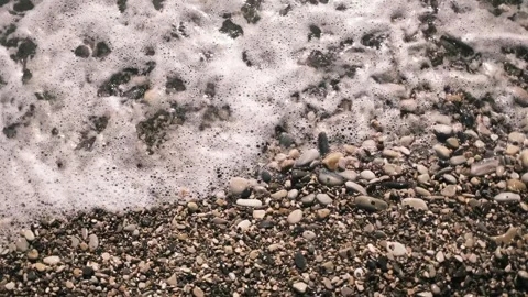 Sea waves rolling over a pebble beach on the Black Sea coast. Close top view of Stock Footage 325738303