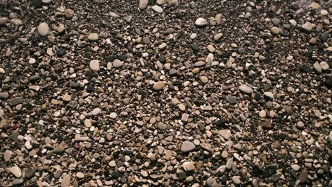Sea waves rolling over a pebble beach on the Black Sea coast. Close top view of Stock Footage 325738380