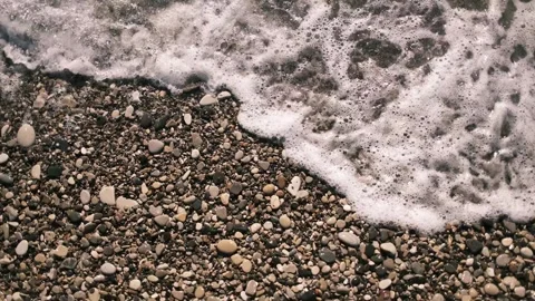 Sea waves rolling over a pebble beach on the Black Sea coast. Close top view of Stock Footage 325738491