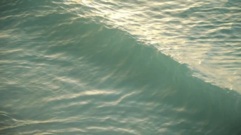 Sea waves rolling on sandy beach at sunset 動画素材 105457810