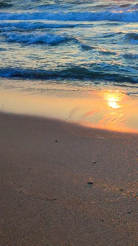 Sea waves rolling onto sandy beach of seashore on sunny morning at dawn Vertical Stock Footage 268615434