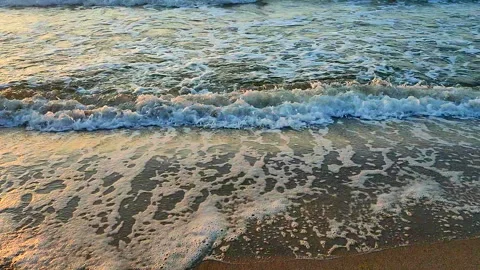 Sea waves rolling sandy beach on the seashore in summer during sunset sunrise Stock Footage 284338743