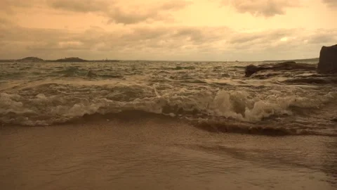 Sea waves run onto the sandy shore in the evening Stock Footage 131883476