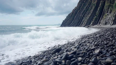 The sea waves rush onto the pebble beach. Stock Footage 246875435