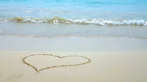 Sea waves on the sand close-up Painted Heart on the Sand Stock Footage 87305783