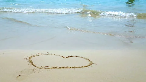 Sea waves on the sand close-up Painted Heart on the Sand Stock Footage 87305825