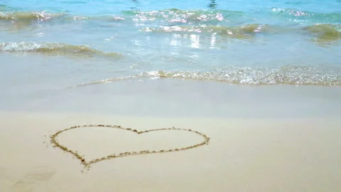 Sea waves on the sand close-up Painted Heart on the Sand Stock Footage 87305852