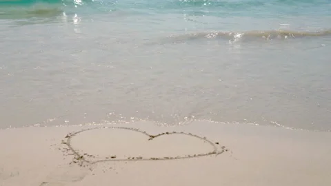 Sea waves on the sand close-up Painted Heart on the Sand Stock Footage 87305856