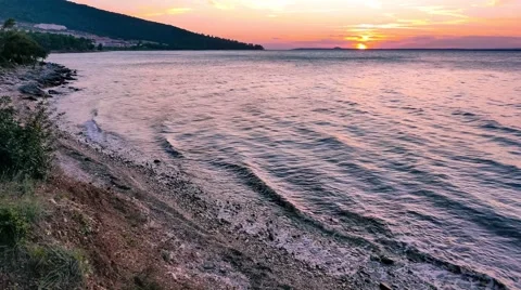 Sea waves on sandy beach at sunset. 4k Stock Footage 61750374
