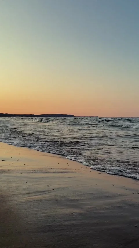The sea waves on a sandy beach at sunset Stock Footage 279081888