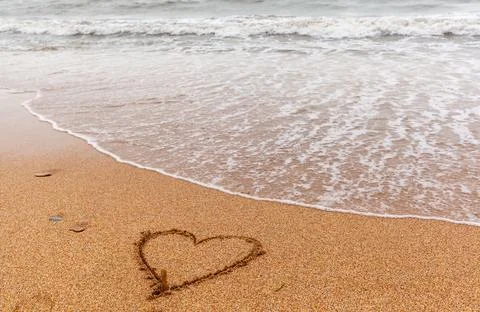 Sea waves on the sandy shore on a cloudy day. Rest on the sea Stock Photos