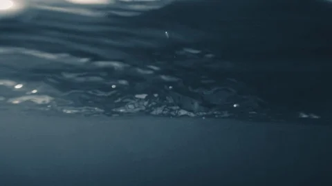 Sea waves shimmer on the counterlight of the setting sun, water hits the camera Stock Footage 124160914