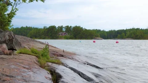 Sea waves slowly splash onto the empty stony shore of marina in the early evenin Stock Footage 280406283