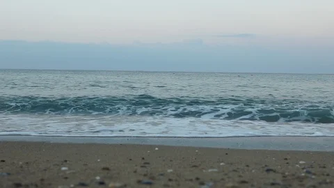 Sea waves smoothly roll onto the sandy shore. Stock Footage 117729264