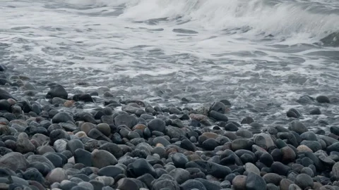 Sea waves splash onto the pebbly shore Stock Footage 301390897