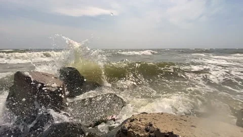 Sea waves with splashes and foam crash against the rocky shore 스톡 동영상 159187392