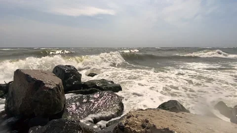 Sea waves with splashes and foam crash against the rocky shore 스톡 동영상 159187461