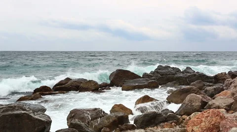 Sea waves with splashes break about stones early in the morning Video stock 43201210