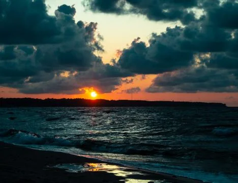 Sea waves with splashes at sunset or sunrise. Ocean waves washing coast sand  Stock Photos