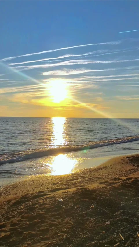Sea waves splashing on the beach sand at sunset. A beach with pebbles. 動画素材 298211634