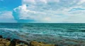 Sea waves splashing on stony beach, low clouds in sky. Loopable video with sound 4k or 4k+ Resolution