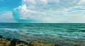 Sea waves splashing on stony beach, low clouds in sky. Loopable video with sound HD Footage