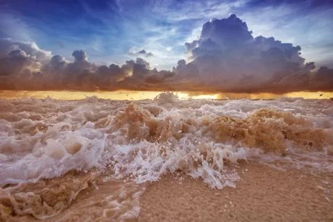 Sea waves on the sunset cloudy sky background Stock Photos