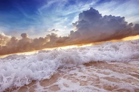 Sea waves on the sunset cloudy sky background Stock Photos