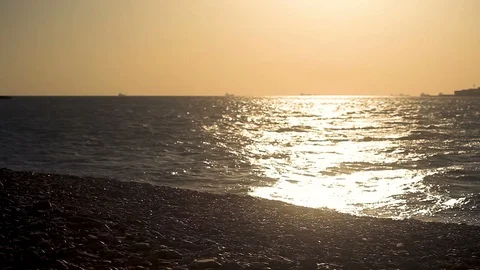 Sea waves at sunset, the Guy runs up to the water Stock-Footage 113695075