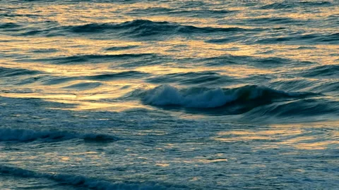 Sea waves of sunset with light reflection by the beach, close up, real time. 库存影片 232384563