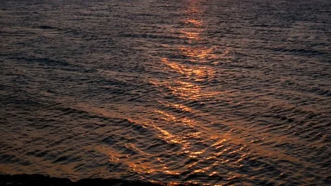 Sea waves on the sunset rays. Reflection of sunrise on the ocean. Slow motion Stock Footage 125524638
