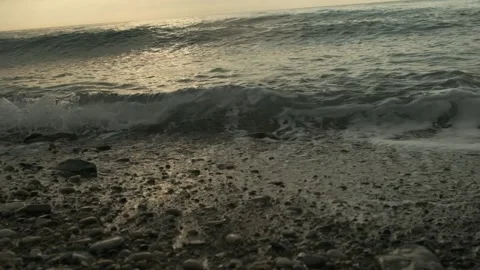 Sea waves at sunset on a stone beach slow motion Stock Footage 171639962