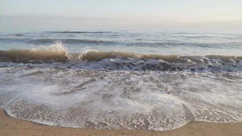Sea waves surf on sand beach with clouds on horizon. Quiet and slow swash Stock Footage 98887224