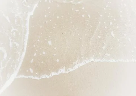 Sea waves on the surface of the sandy beach.Soft waves of blue sea and sand  Stock Photos