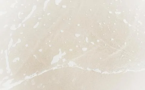 Sea waves on the surface of the sandy beach.Soft waves of blue sea and sand  Stock Photos