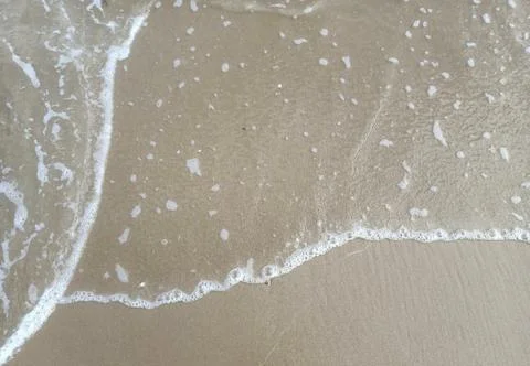 Sea waves on the surface of the sandy beach.Soft waves of blue sea and sand  Stock Photos