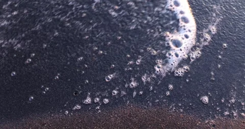 Sea waves wash away Hate word from dark sand on beach Stock Footage 250328321