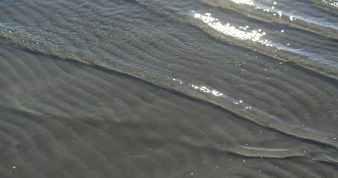 Sea Waves Washing Over Sandy Beach with Sun Reflections 4K 動画素材 339274916