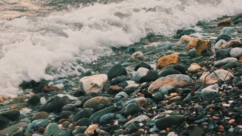 Sea Waves Washing Over Smooth Pebbles on a Shingle Beach Stock Footage 345144563