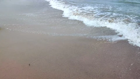 Sea waves with white foam roll on the sandy beach of the seashore close-up. Stock Footage 212945777