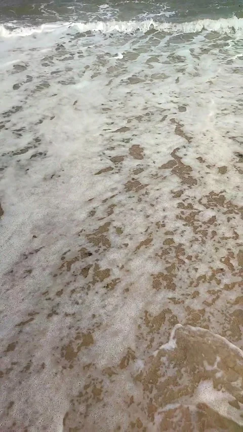 Sea waves with white foam roll on the sandy beach of the seashore close-up. Stock Footage 214622874