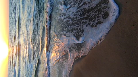 Sea waves white foam rolling on sandy beach sea coast dawn sunset sea Vertical Stock Footage 241337867