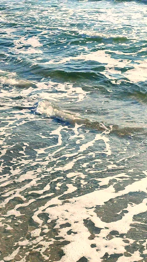 Sea waves white foam rolling onto sandy beach shore. Clean blue water Vertical Stock Footage 305865581