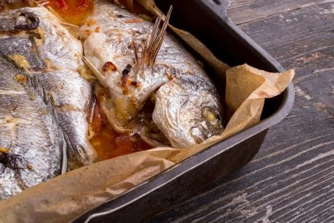 Seabass fish on a baking sheet Stock Photos