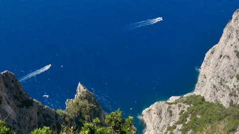 Seabirds flying around rock cliffs mountain motorboats sailing in sea background Stock Footage 112345143