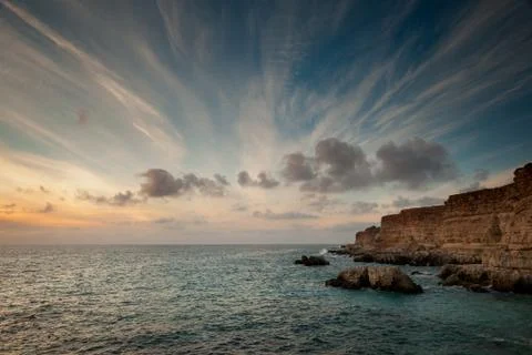 Seacoast with cliffs at sunset. Stock Photos