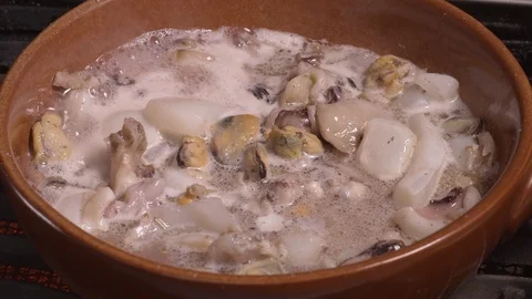 Seafood chowder boiling in a clay pan in UHD Video stock 94661241