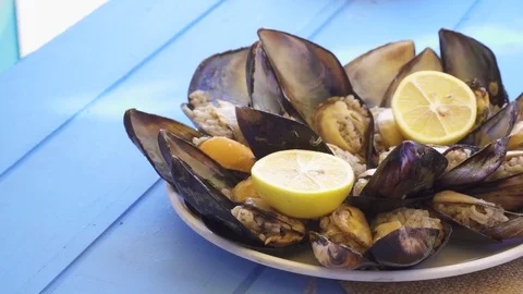 Seafood Dish open and ready mussels on blue table Stock Footage 80310062