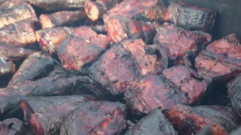 Seafood, huge chunks of fresh hot smoked tuna on traditional African oven grill  Video stock 345764163