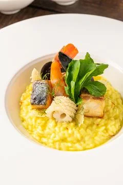 Seafood risotto, risotto alla pescatora, served on a white porcelain plate Stock Photos